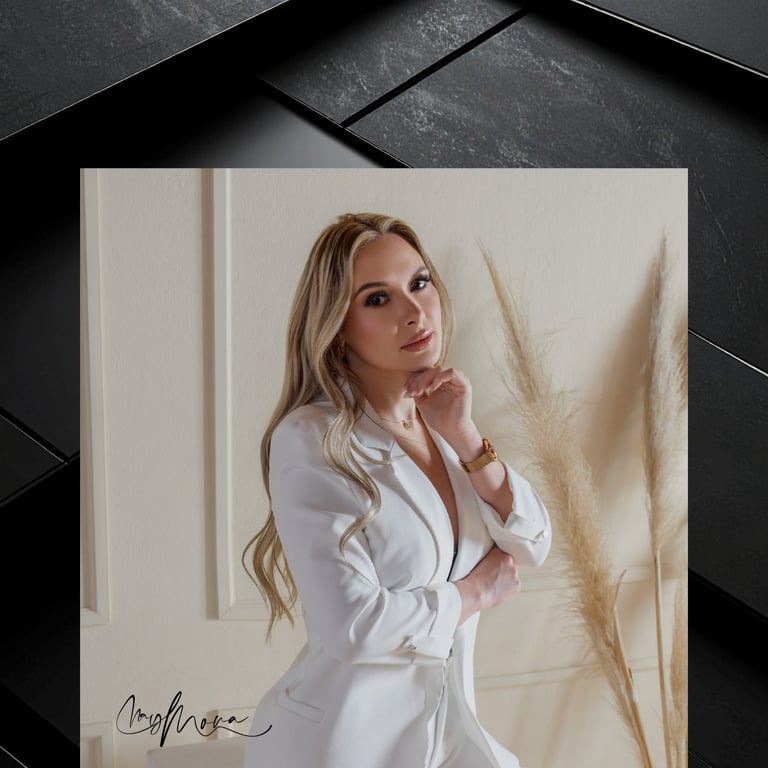 Woman in white button-up shirt posing thoughtfully against neutral backdrop with dried pampas grass